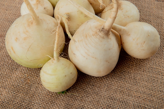 Close-up view of white radishes on sackcloth background with copy space