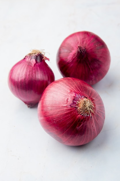 Close-up view of whole red onions on white background