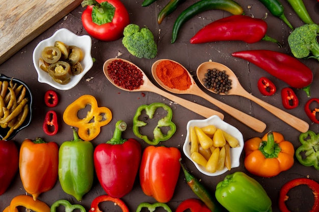 Vista del primo piano di peperoni interi, salati, affettati con broccoli e spezie