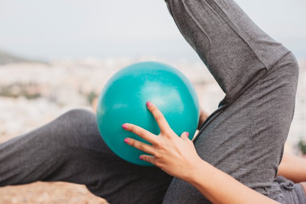 Close up view of woman doing exercise with ball