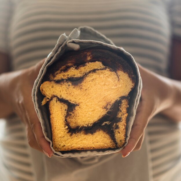 Close-up view of a woman holding a sweet bread 