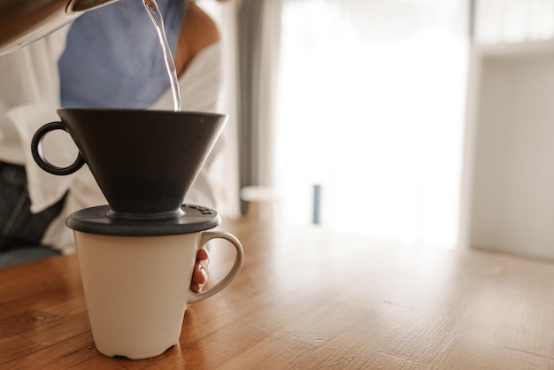 Close up view of woman making coffee in a cup