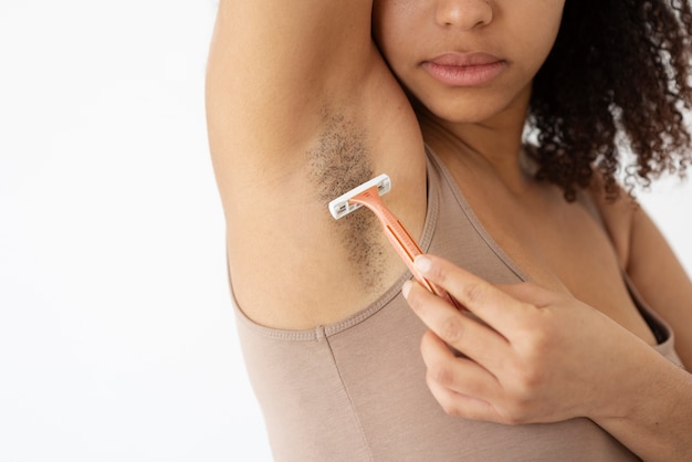 Close-up view of woman removing armpit hair