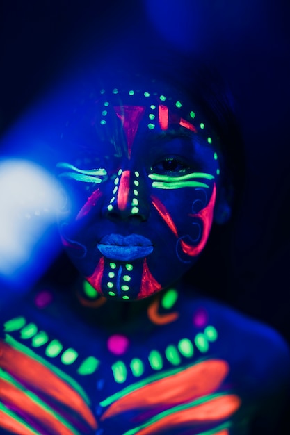 Close-up view of woman with colorful fluorescent make-up