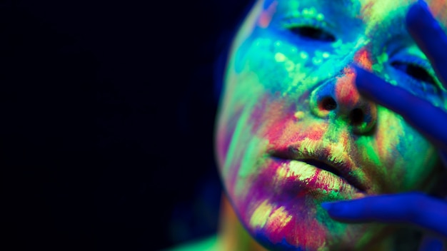 Close-up view of woman with colorful fluorescent make-up