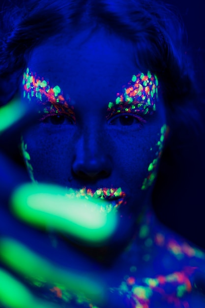 Close-up view of woman with fluorescent make-up