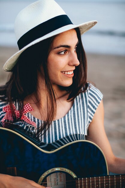 Close up view of woman with guitar at the beach