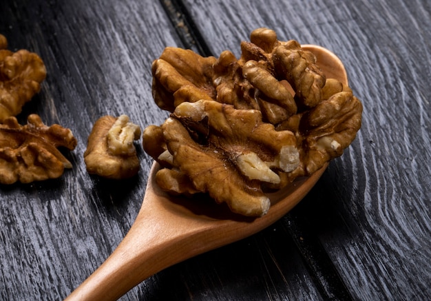 Close up view of a wooden spoon with walnuts on rustic