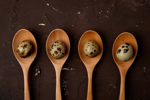 Free photo close-up view of wooden spoons with eggs on maroon