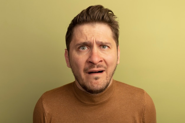 Free photo close-up view of young blonde handsome man isolated on olive green wall