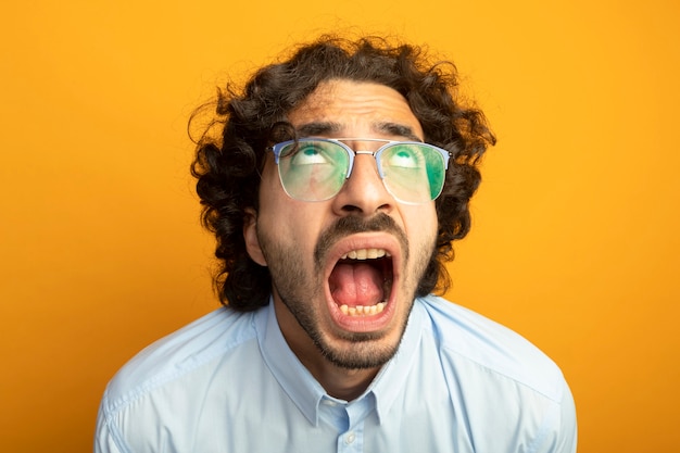 Free photo close-up view of young handsome man wearing glasses isolated on orange wall