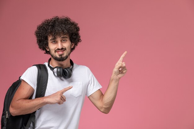 Close up view young man pointing out up with headphone