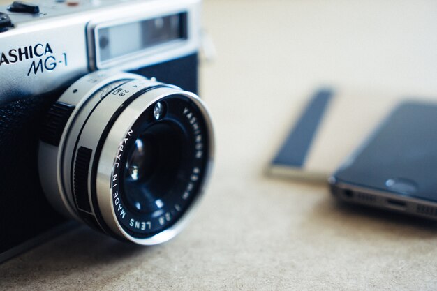 Close-up of vintage camera with blurred smartphone background