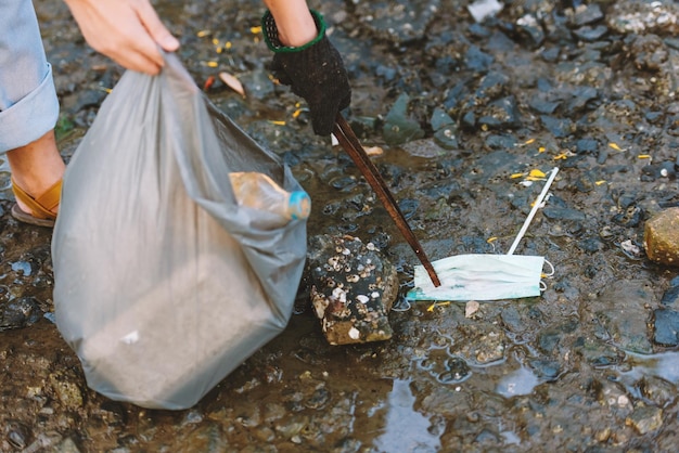 Foto gratuita primo piano per la conservazione dell'ambiente dei volontari aiuta a mantenere e ripulire i rifiuti di plastica e schiuma sulla spiaggia e nell'area del parco giornata mondiale del volontariato per l'ambiente