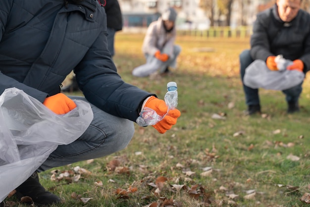 Free photo close up volunteers collecting garbage