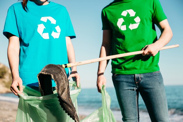 Close up of volunteers collecting trash at the beach