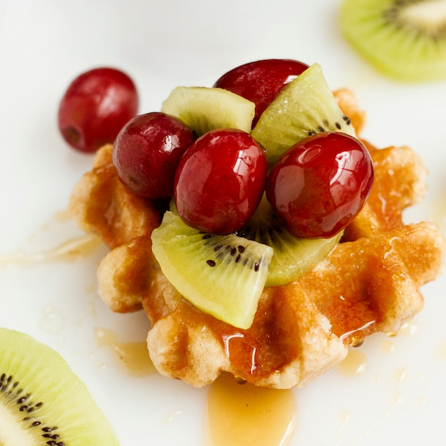 Close up waffle with honey and mix of fruits