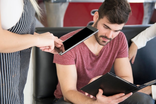 Close-up of waitress taking customer order on digital tablet