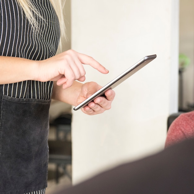 Close-up of waitress using digital tablet