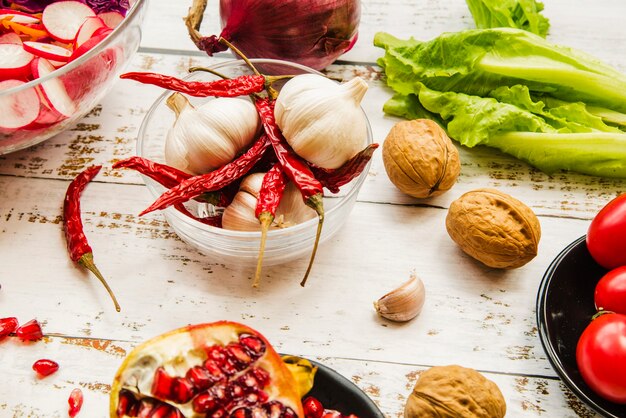 Close-up of walnut; red chilies; pomegranate; lettuce; garlic on table