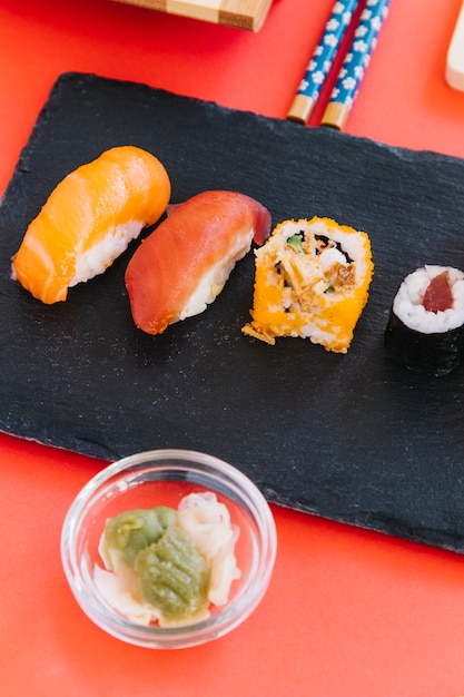 Foto gratuita wasabi del primo piano vicino a sushi