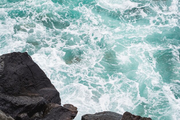 Close-up wavy water at rocky shore