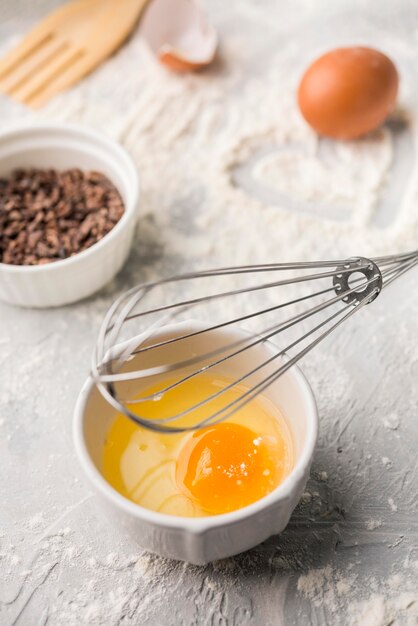 Close-up whisk with egg on the table