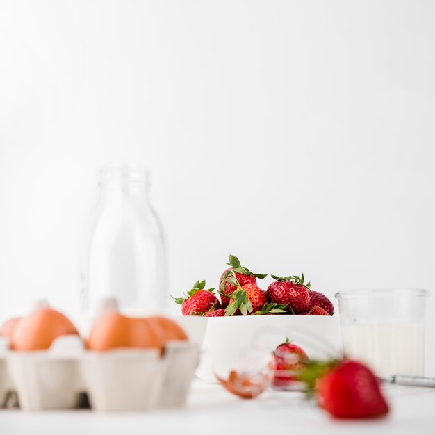 Close-up whisk with strawberries and eggs