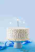 Free photo close-up of white birthday cake with burning sparkler