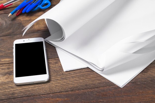 Крупный план белый пустой документ с сотовый телефон на деревянный стол