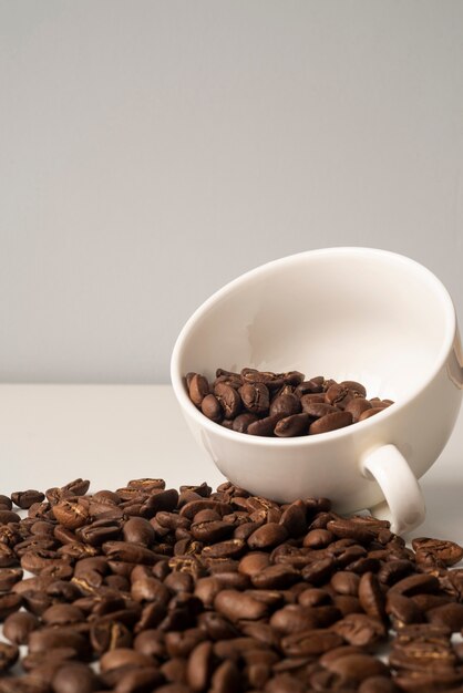 Close-up white cup filled with coffee beans