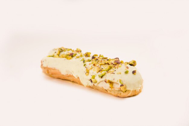 Close up of white eclair with nuts