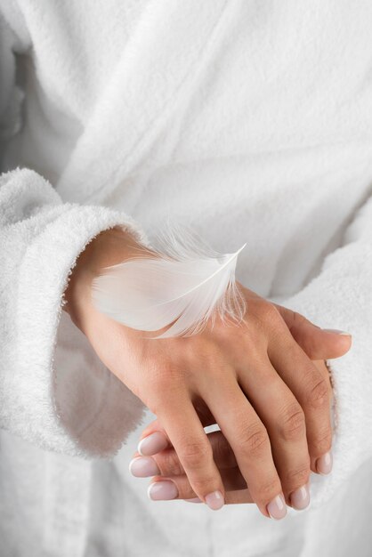 Close-up white feather on hand