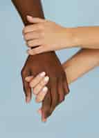 Free photo close-up white hands holding black hand