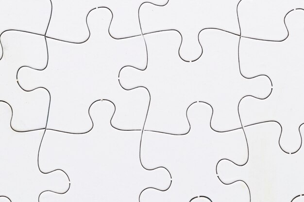 Close-up of white jigsaw puzzle grid background