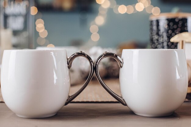 Close up of white mugs of hot drinks. Copy space. New Year eve concept