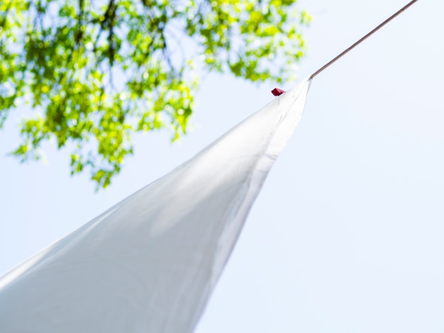 Close-up white sheet drying on the line