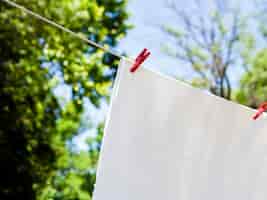 Free photo close-up white sheet drying on the line