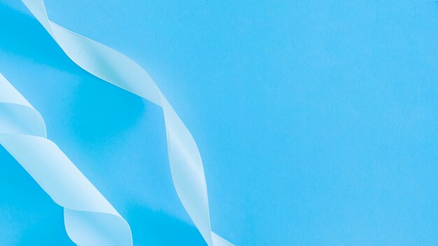 Close-up of white transparent ribbon on blue backdrop