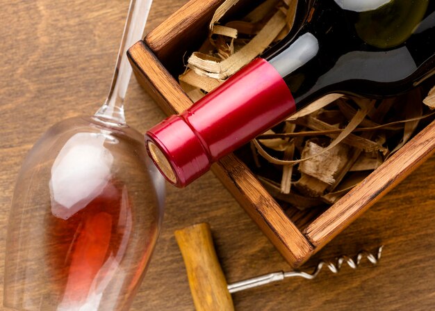 Close-up wine bottle and glass with corkscrew