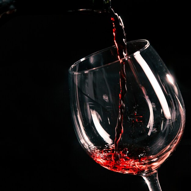 Крупным планом вино, льющееся в стекло