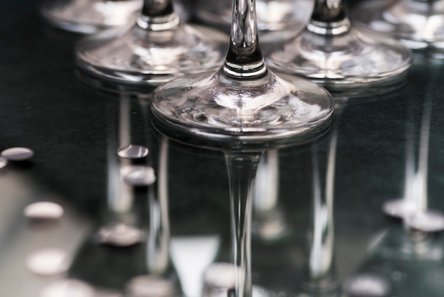 Close-up of wineglasses base reflecting on table