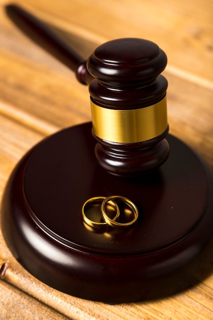 Close-up with judge gavel on stand with wedding rings