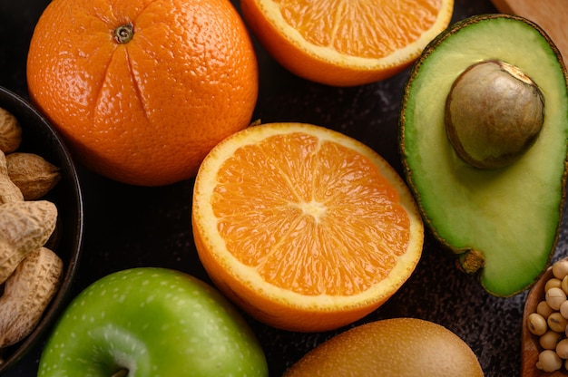 Закройте вверх с ломтиком свежего апельсинового яблока, кивиа, арахиса и авокадо.