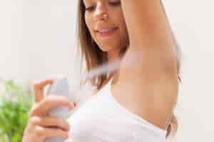 Free photo close up of woman applying deodorant on under arm