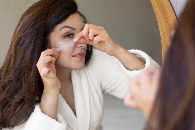 Close up woman applying eye patch