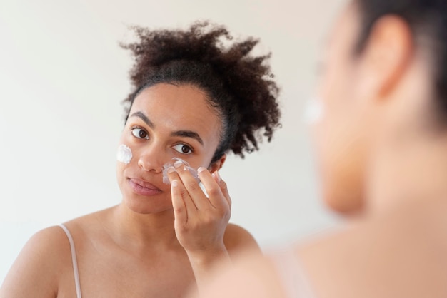 Close up woman applying face cream