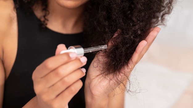 Close up woman applying hair product