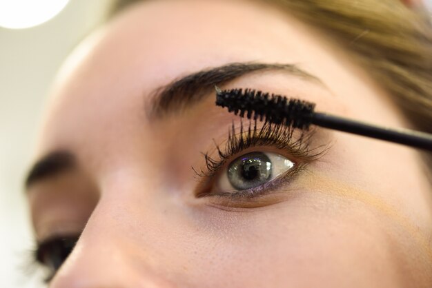 Close-up of woman applying mascara to her lashes