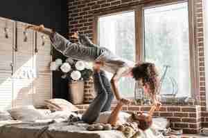 Free photo close-up of a woman balancing man's feet on bed at home